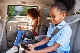 Children Using Digital Devices On Car Journey