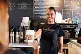 Female Barista Serving Customer With Takeaway Coffee In Cafe
