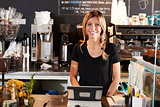Portrait Of Female Barista Behind Counter In Coffee Shop