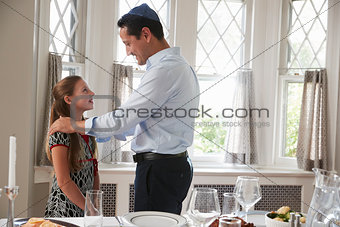 Jewish man standing with daughter before Shabbat meal