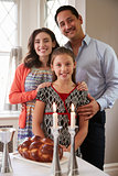Jewish family smile to camera before Shabbat meal, vertical