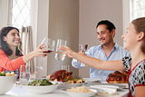 Jewish family raising glasses at the table for Shabbat meal