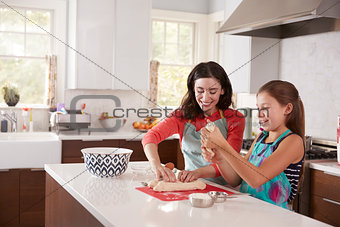 Jewish mother and daughter preparing dough for challah bread