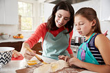 Jewish mother and daughter glazing dough for challah bread
