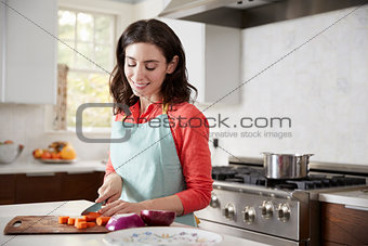 Woman chopping carrots in kitchen for Jewish passover meal