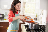 Woman cooking carrots in kitchen for Jewish passover meal