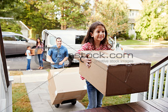 Children Helping Unload Boxes From Van On Family Moving In Day