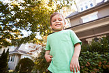 Portrait Of Young Boy Playing In Garden At Home