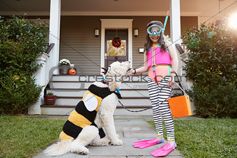 Girl With Dog Wearing Halloween Costumes For Trick Or Treating
