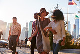 Group Of Friends Walking With Manhattan Skyline In Background