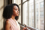 Young black businesswoman looking out of window