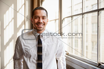 Young Hispanic businessman smiling to camera, close up