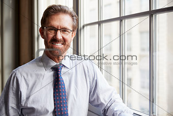 Senior businessman in shirt smiling to camera, close up