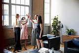 Female colleagues high five at a motivational meeting