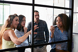 Young colleagues at a meeting visualising on a glass wall