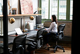 Young woman working alone in a compact office
