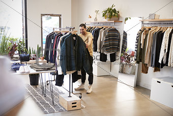 Young Hispanic man browsing through clothes in a shop