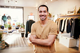 Young Hispanic man smiling to camera in a clothes shop