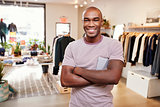 Young black man smiling to camera in a clothes shop