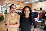 Young adult couple smiling to camera in a clothes shop