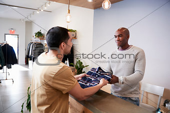 Man serving customer at the counter in a clothing store