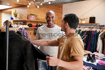Two young men shopping for clothes in a clothes shop