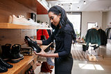 Young black woman looking at shoes on display in a shop