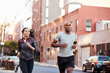 Young black couple jogging in Brooklyn street, close up