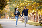 Young Hispanic couple walking hand in hand in Brooklyn park