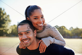 Young couple smiling at camera in Brooklyn, close up