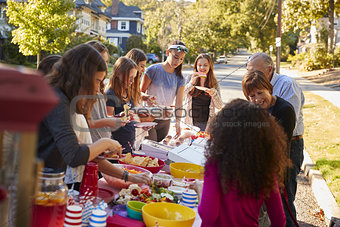 Neighbours standing around a table at a block party