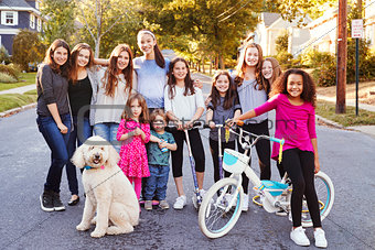 Group of kids with dog smile to camera in a residential street