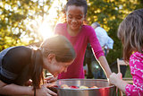 Young girls laugh while apple bobbing at a backyard party