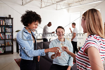 Three friends in a loft apartment making a toast,cheers, close up