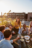 Friends talking at a party on a rooftop, vertical