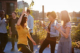 Female friends dancing and drinking at a rooftop party