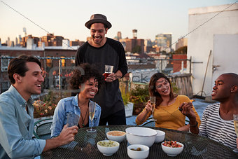Six adult friends enjoying a party on a rooftop, close up