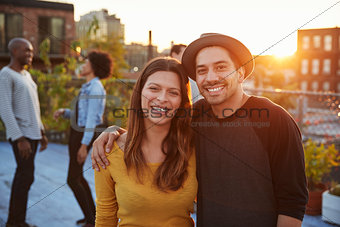 Young adult couple embracing at a rooftop party