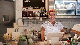 Young woman waiting behind the counter in a butcher's shop