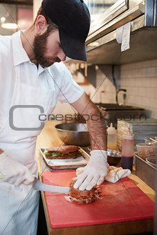 Man in butcher's shop preparing food for customer, vertical