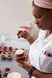 Young black woman preparing food in a bakery, close up