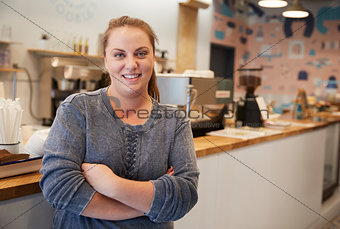 Young woman smiling to camera at the counter in a bakery