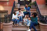 Two families with kids sitting on front stoops