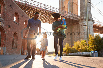 Young family with two daughters walk on a street