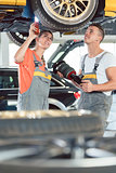 Experienced female auto mechanic with colleague at repair shop