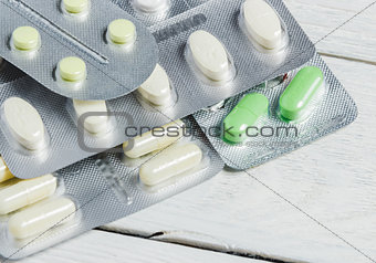 Set of Various Tablets and Capsules in Blisters on White Wooden Background with Copy Space. Medicine Concept.