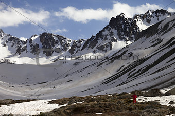 Hiker in spring snowy mountains