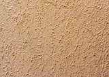 fragment of beige wall with decorative plaster of waves