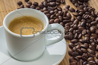 Coffee Cup on a saucer and grains of black coffee