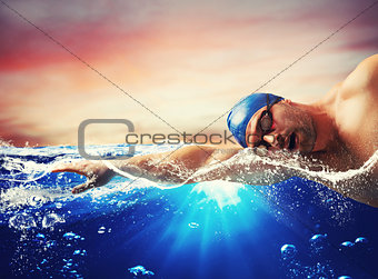 Boy swims in a blue deep water